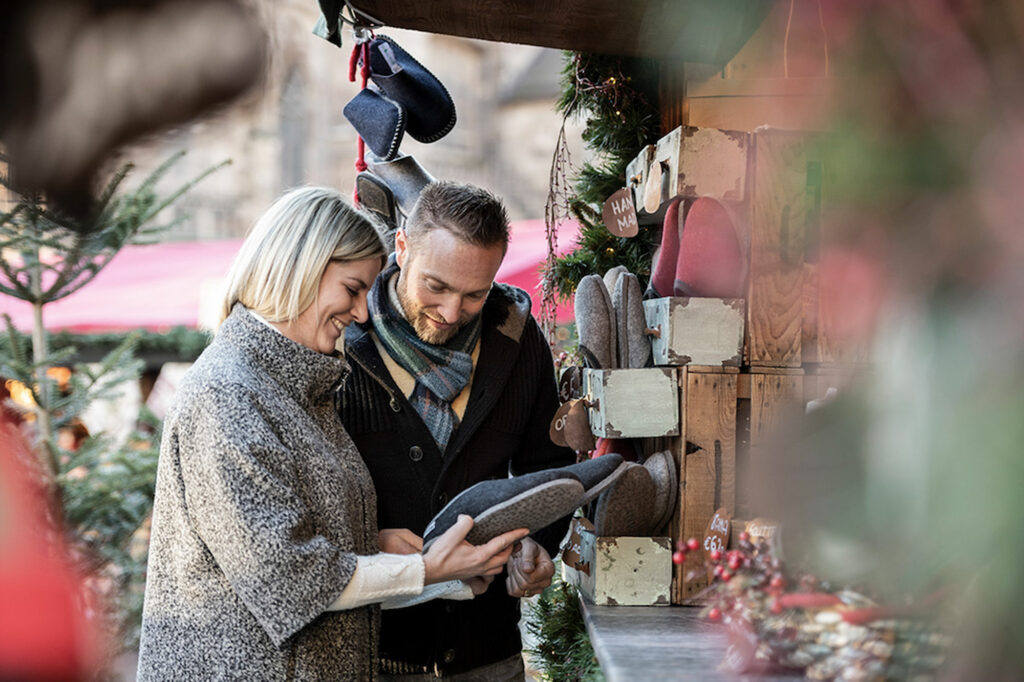 Due persone che fanno acquisti in un mercatino di Natale